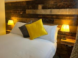 a bedroom with a bed with pillows and two lamps at The Brookmill in London