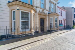 a building with a fence on the side of a street at The Retreat in Wigton