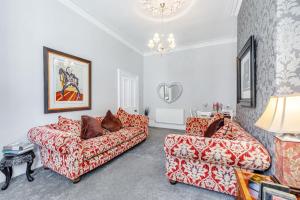 uma sala de estar com dois sofás e um candeeiro em The Retreat em Wigton