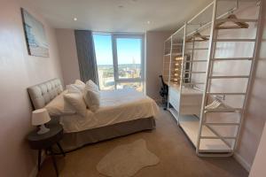 a bedroom with a bed and a book shelf at Amazing London City Skyline View & Transport Links in Barking
