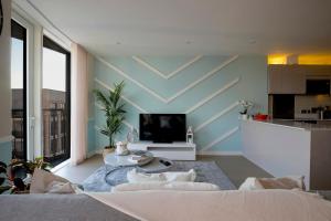uma sala de estar com um sofá e uma mesa em Stunning Apartment with London City Skyline view & Great Transport Links em Barking