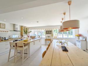 a large kitchen with a wooden table and chairs at Priory Coach House - Church Norton in Selsey