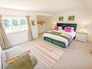 a bedroom with a king sized bed and a couch at Priory Coach House - Church Norton in Selsey