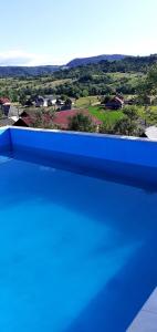 a blue pool with a view of the countryside at Pensiunea Anca in Rona de Jos