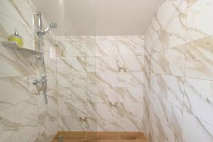 a bathroom with a shower with marble tiles at Sobe - Rooms Drvorez in Banja Luka