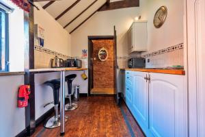 a kitchen with blue cabinets and a brick wall at Finest Retreats - The Hayloft at Greystones in Swinderby