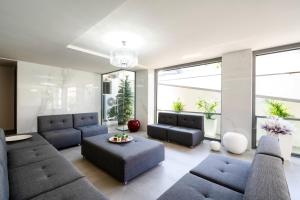 sala de estar con muebles azules y ventanas grandes. en Evitel Luxury Living, en Chaniotis