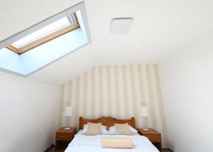 a bedroom with a bed and a skylight at Sobe - Rooms Drvorez in Banja Luka