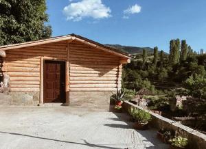 een kleine houten hut met een deur voor de deur bij Lodges VEIS in Kamenicë