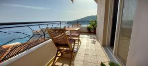 a balcony with two chairs and a table and a view of the water at Beleri House in Himare