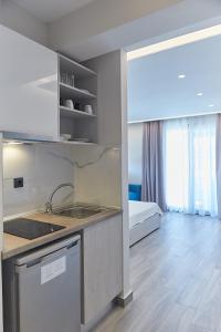 a kitchen with a sink and a bed in a room at Albatros Luxury Suites in Nea Vrasna