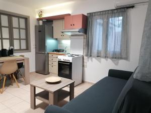 cocina y sala de estar con sofá y mesa en petite nafplio sofos apartment en Nauplia