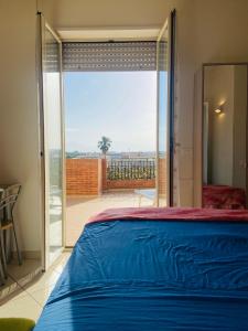 Schlafzimmer mit einem Bett und einer Glasschiebetür in der Unterkunft Monolocale con terrazza a pochi passi dal mare con Stabilimento balneare convenzionato in Alba Adriatica