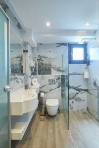 a bathroom with a sink and a toilet and a shower at Albatros Luxury Suites in Nea Vrasna