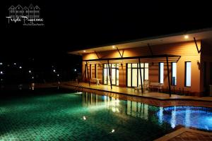 a swimming pool in front of a building at night at Triple P Home Resort in Pak Chong