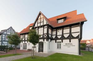 Hotel Am Burgmannshof في فونستورف: مبنى ابيض واسود بسقف احمر