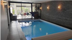 een groot zwembad in het midden van een huis bij Villa les Agapanthes avec piscine et SPA chauffée dans votre appartement in Hardelot-Plage