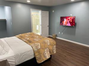 a bedroom with a bed and a tv on the wall at Blue Seal Inn in Pismo Beach