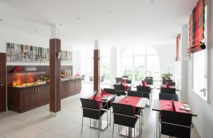 a restaurant with red tables and chairs and a buffet at Hotel Am Burgmannshof in Wunstorf