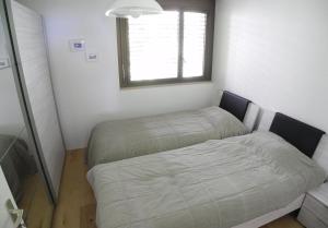 アスコナにあるCasa Monte App 6000のベッドと窓が備わる小さな客室です。