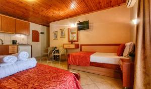 une chambre d'hôtel avec deux lits et une cuisine dans l'établissement Rodon Garden Centre, à Sarti