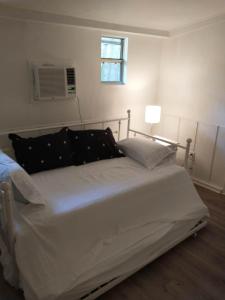 a white bed in a bedroom with a window at The Van Zant House in Jacksonville