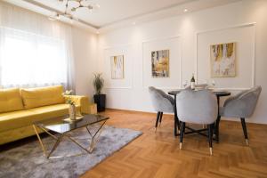 a living room with a yellow couch and a table at July in Trebinje