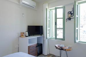 1 dormitorio con 1 cama, TV y ventana en Rain Rooms and Food, en Marmaris