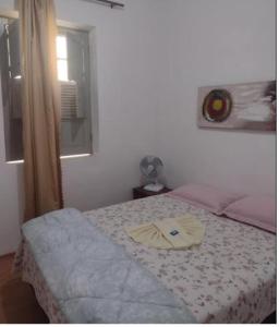 Un dormitorio con una cama con una toalla. en HOTEL SACRA FAMILIA -15 Km da Terra dos Dinos en Sacra Família do Tinguá