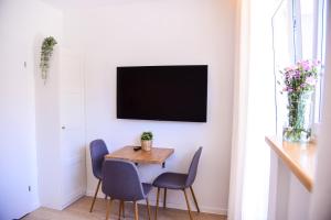 comedor con mesa, sillas y TV en Apartamenty Turystyczna 25 en Kudowa-Zdrój