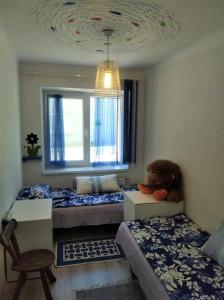 um quarto com duas camas e um urso de peluche sentado na cama em Apartamentai KINTAI em Kintai