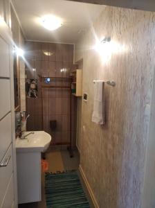 y baño con lavabo y ducha. en Apartamentai KINTAI en Kintai
