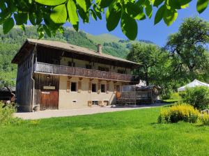 an old farm building with a barn and a train at Appartement dans chalet 5 chambres 130 m2 centre village in Montriond