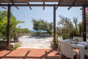 a patio with a table and chairs and a view of the beach at Piccolo Mondo Castro apt 64 in Castro di Lecce