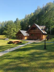 a log cabin in the middle of a park at Mana Village - Jacuzzi & Sauna in Barłomino