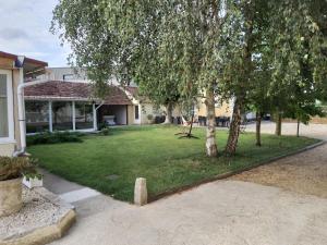 une cour avec des arbres devant une maison dans l'établissement Au Bord de L'Eau, à Écluzelles