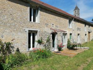 CommesにあるMaison renovee en pierres séjour spacieux avec jardin et terrasse aménagée près Omaha beach & Bayeux à 5mn de la mer tous commercesの外にテーブルがある石造りの建物