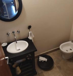 Un baño con lavabo, inodoro y espejo. en El Agasajo, Córdoba Capital casa de 3 habitaciones, en Córdoba 2 fotos más