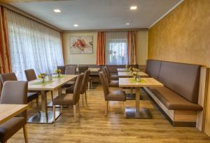uma sala de jantar com mesas e cadeiras de madeira em Pension Liesertalerhof em Trebesing