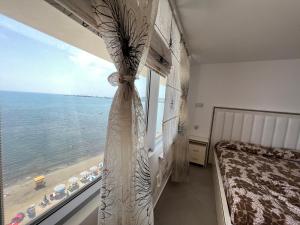 a bedroom with a window with a view of the ocean at Luxury sea view duplex in Durrës