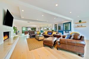 una gran sala de estar con muebles de cuero y chimenea. en Sunshine Stunner, en Carlsbad