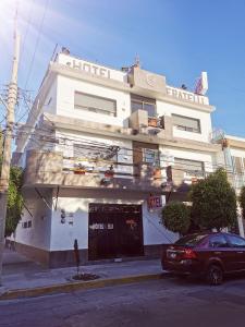 a building with a car parked in front of it at Hotel Fratelli in Aguascalientes