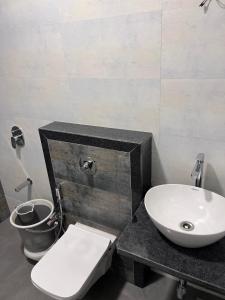 een badkamer met een wit toilet en een wastafel bij Pinaki Comfort Stay, Vile Parle in Mumbai