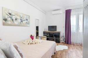 a white bedroom with a bed and a tv at Irene Bed & Breakfast Tisno in Tisno