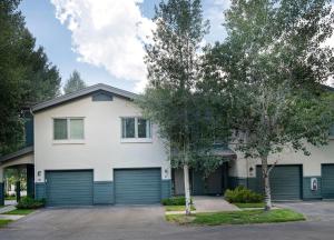 a white house with two garage doors at Greenbrier Townhouse 36 in Avon