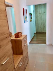 a room with a wooden dresser and a mirror at Apartman Leon Lux in Leskovac