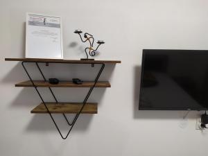 a flat screen tv sitting next to a shelf at Apartman Leon Lux in Leskovac