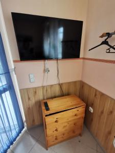 a television on the corner of a room with a wooden table at Anno 2000 in Balatonlelle