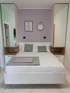 Cette chambre comprend un grand lit blanc et un miroir. dans l'établissement Room and terrace, à Krk