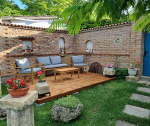 a patio with two couches and a wooden deck at Casa David&Alexia 2 Mai in 2 Mai